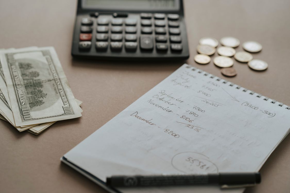 Planejamento de finanças pessoais com calculadora, dinheiro e caderno de anotações